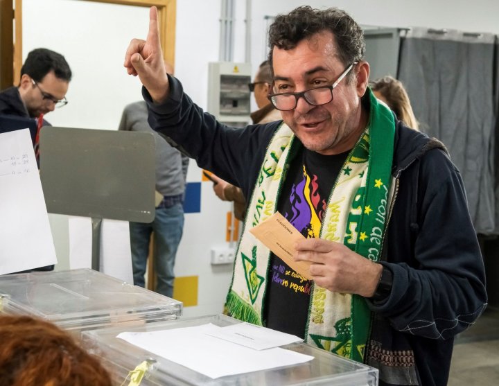 Un ciudadano ataviado con la bufanda del Betis vota en la jornada electoral