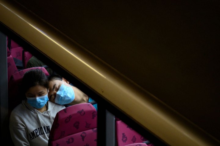 Una pareja descansa en un autobús en Hong Kong sin retirarse las máscaras de protección del contagio del coronavirus. Philip FONG / AFP
