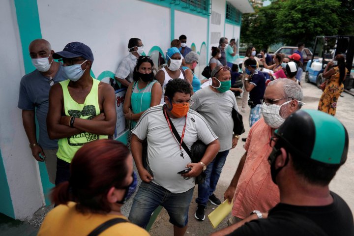 People wearing face masks wait to enter the first wholesale outlet for private eateries, during the global outbreak of the coronavirus disease (COVID-19), in Havana, Cuba, July 28, 2020. Picture taken July 28, 2020. REUTERS/Alexandre Meneghini