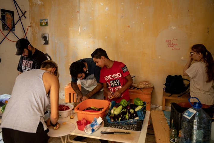 Volunteers from the community based group 'Food Not Bombs' cut and prepare fresh food to make five hundred meals for people in need at a damaged apartment block on August 14, 2020 in Beirut, Lebanon. The explosion at Beirut's port last week killed over 200 people, injured thousands, and upended countless lives. There has been little visible support from government agencies to help residents clear debris and help the displaced, although scores of volunteers from around Lebanon have descended on the city to help clean. (Photo by Chris McGrath/Getty Images)