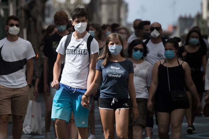 People wear protective face masks as they stroll along a street in Nantes, western France on August 21, 2020, as face masks became compulsory in the city center and some areas to stem the spread of the COVID-19 disease caused by the novel coronavirus. (Photo by Loic VENANCE / AFP)