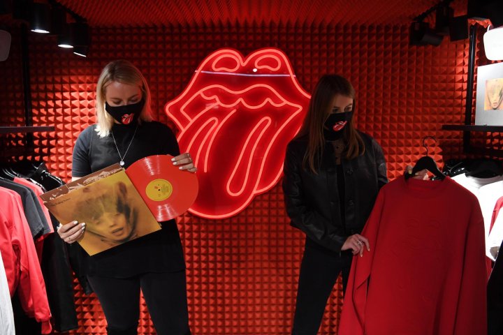 Photo: Workers pose holding good branded with the British Band 'The Rolling Stones' during a media-call for the 'RS No. 9 Carnaby' store in London