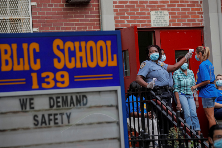 In pictures: School Safety Officers check a teacher's temperature for safety reasons outside a school building, as preparations begin for the delayed start of the school year, following the outbreak of the coronavirus disease (Covid-19 ) in the Brooklyn borough of New York City.